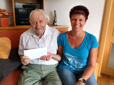 Foto (S. Viertl): Josef Viertl übergibt Reisegutscheine an seine Enkelin Katrin Reithmayr, Hausleiterin in der Außenwohngruppe Traismauer-Stollhofen